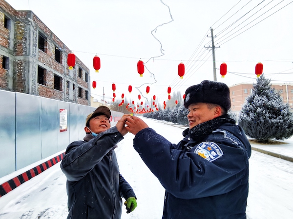 图为民警正与装灯师傅查看彩灯.jpg