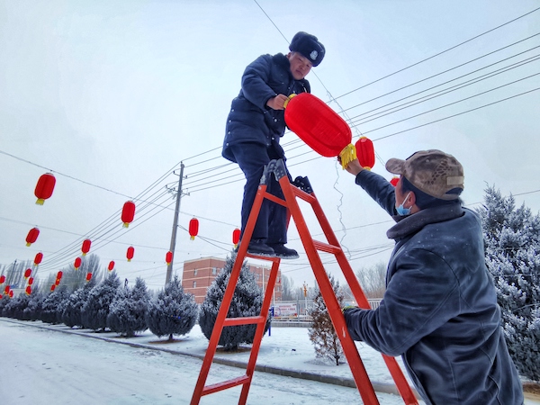 图为彩灯师傅正在给民警递灯笼.jpg